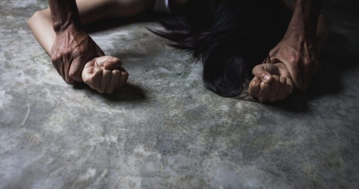Concept of against sexual harassment and rape, Close up of man hands holding a woman hands for rape and sexual abuse concept. dark tone.